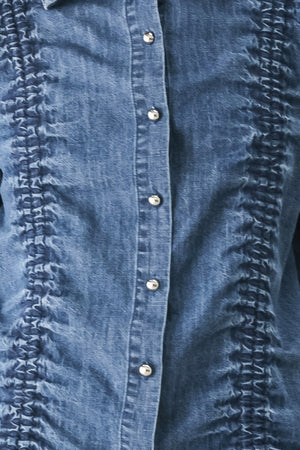 A model wearing a blue denim long-sleeve button-up shirt with ruched detailing | FREEMARKET