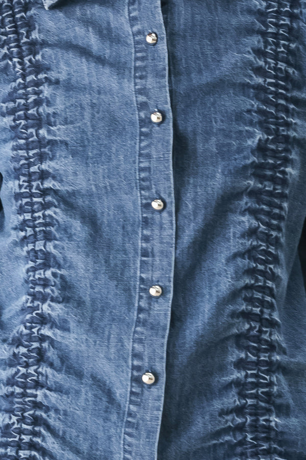 A model wearing a blue denim long-sleeve button-up shirt with ruched detailing | FREEMARKET
