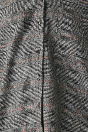 A model wearing a dark gray oversized button-up shirt with a subtle brown and orange windowpane plaid pattern | FREEMARKET