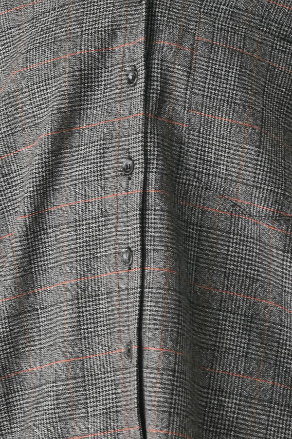 A model wearing a dark gray oversized button-up shirt with a subtle brown and orange windowpane plaid pattern | FREEMARKET