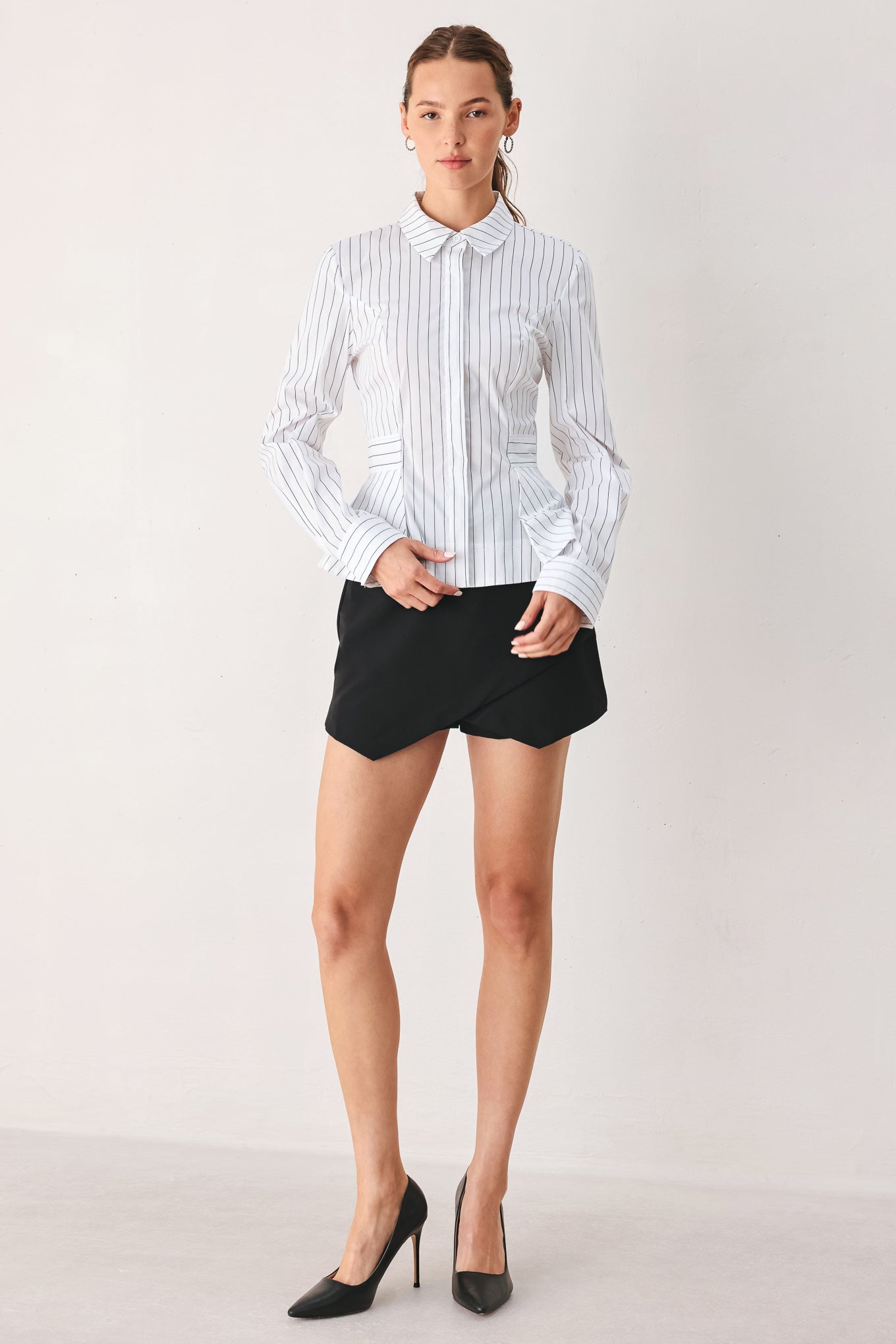 A woman wearing a white long-sleeve button-up shirt with thin vertical black stripes| FREEMARKET