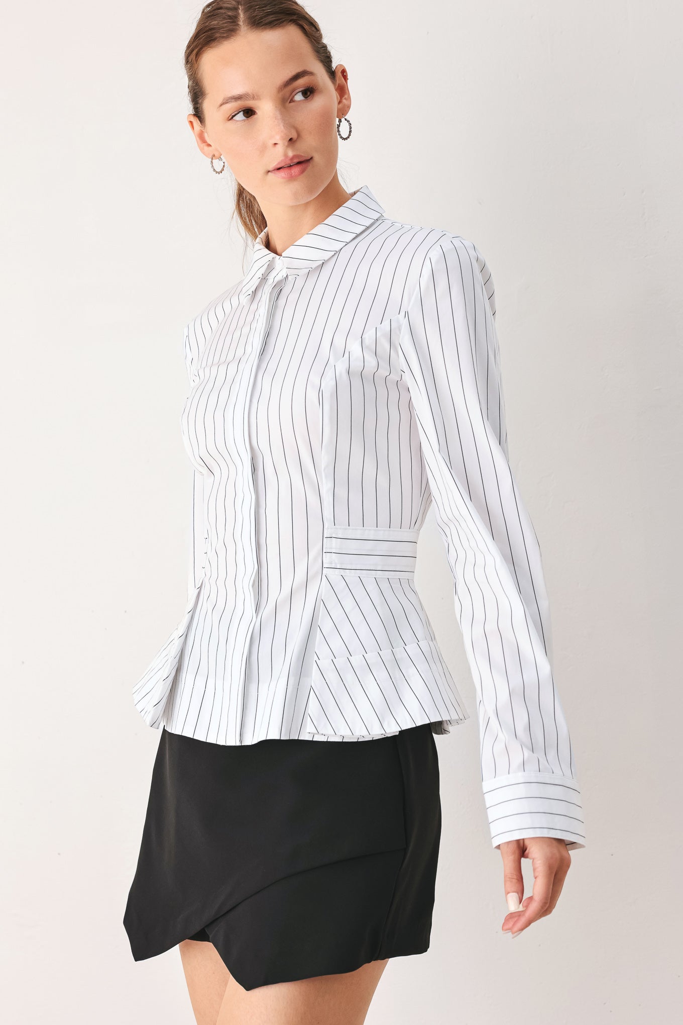 A woman wearing a white long-sleeve button-up shirt with thin vertical black stripes| FREEMARKET