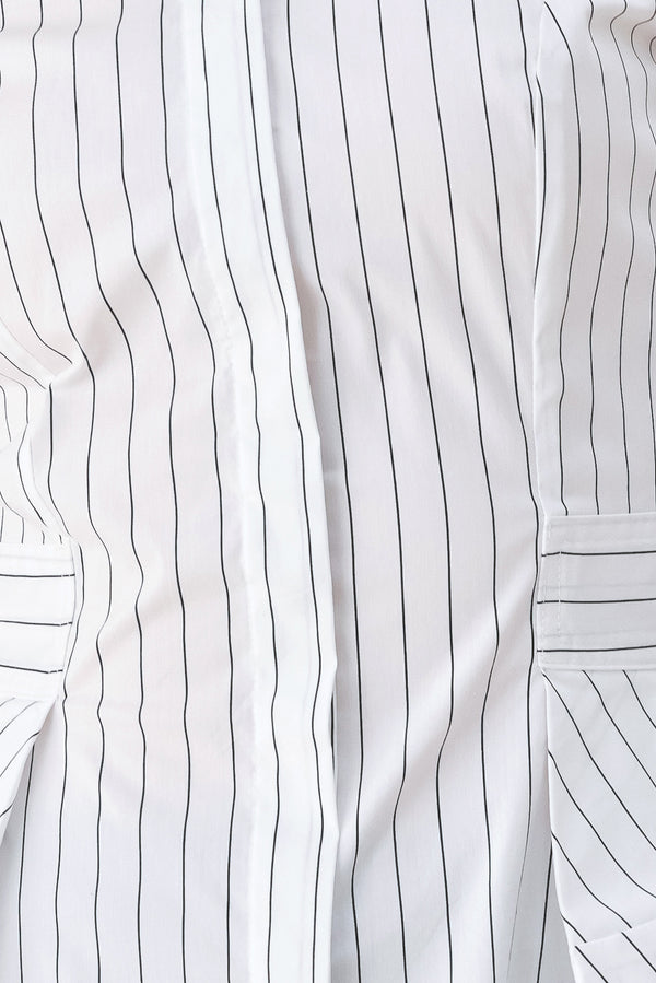 A woman wearing a white long-sleeve button-up shirt with thin vertical black stripes| FREEMARKET