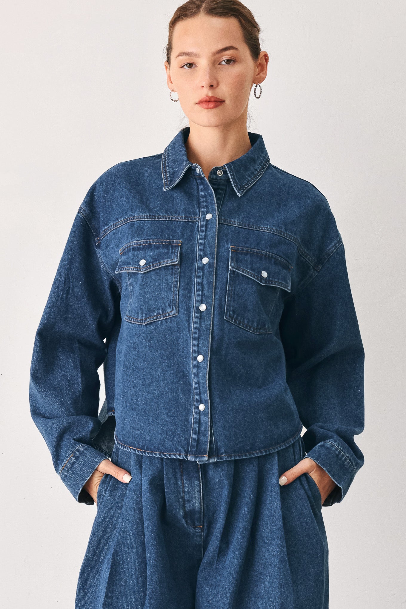 A woman wearing a dark blue denim button-up shirt jacket with two chest pockets | FREEMARKET