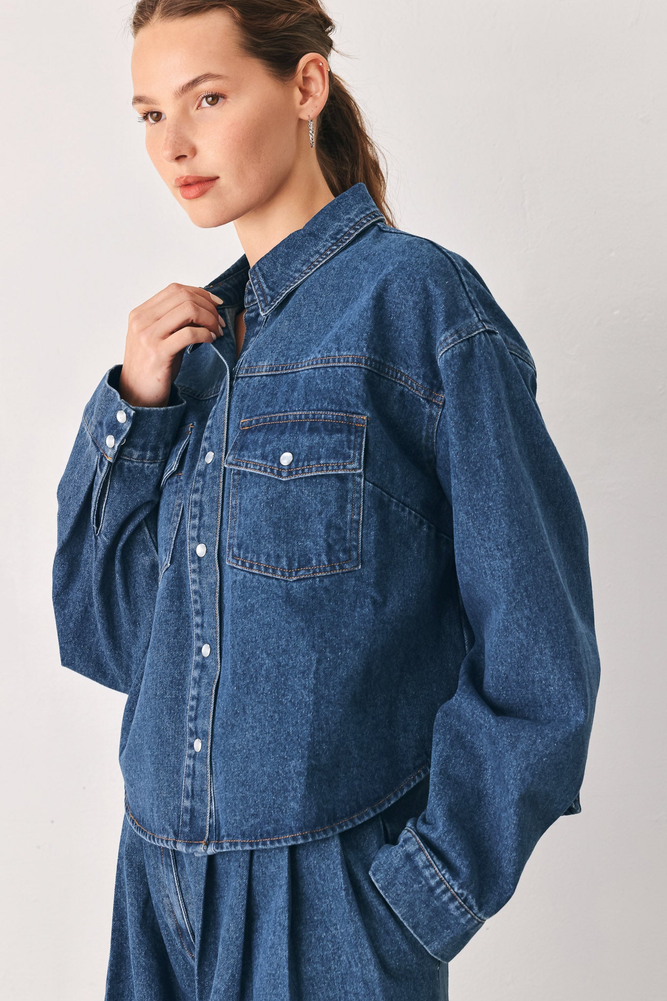 A woman wearing a dark blue denim button-up shirt jacket with two chest pockets | FREEMARKET