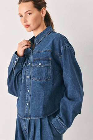 A woman wearing a dark blue denim button-up shirt jacket with two chest pockets | FREEMARKET