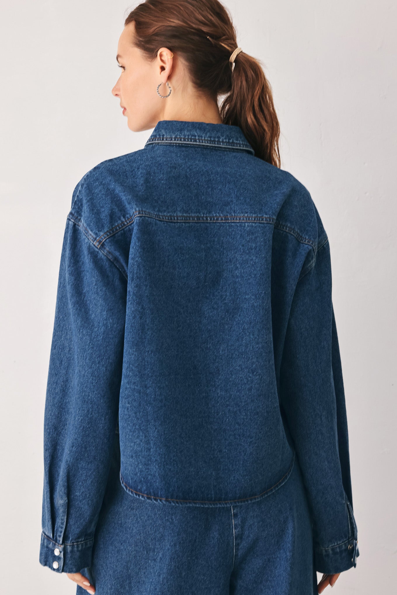 A woman wearing a dark blue denim button-up shirt jacket with two chest pockets | FREEMARKET