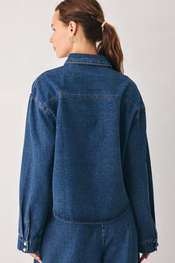 A woman wearing a dark blue denim button-up shirt jacket with two chest pockets | FREEMARKET