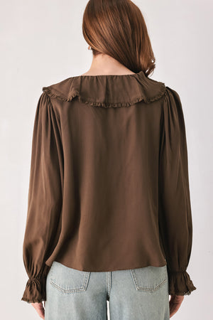 A woman wearing a brown long-sleeve blouse with pleated detailing and layered ruffles on the front | FREEMARKET