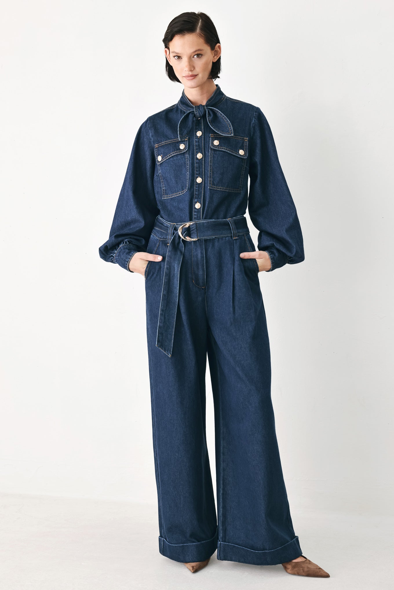 A model wearing a dark blue denim shirt jacket with gold-tone buttons and a bow detail at the collar | FREEMARKET
