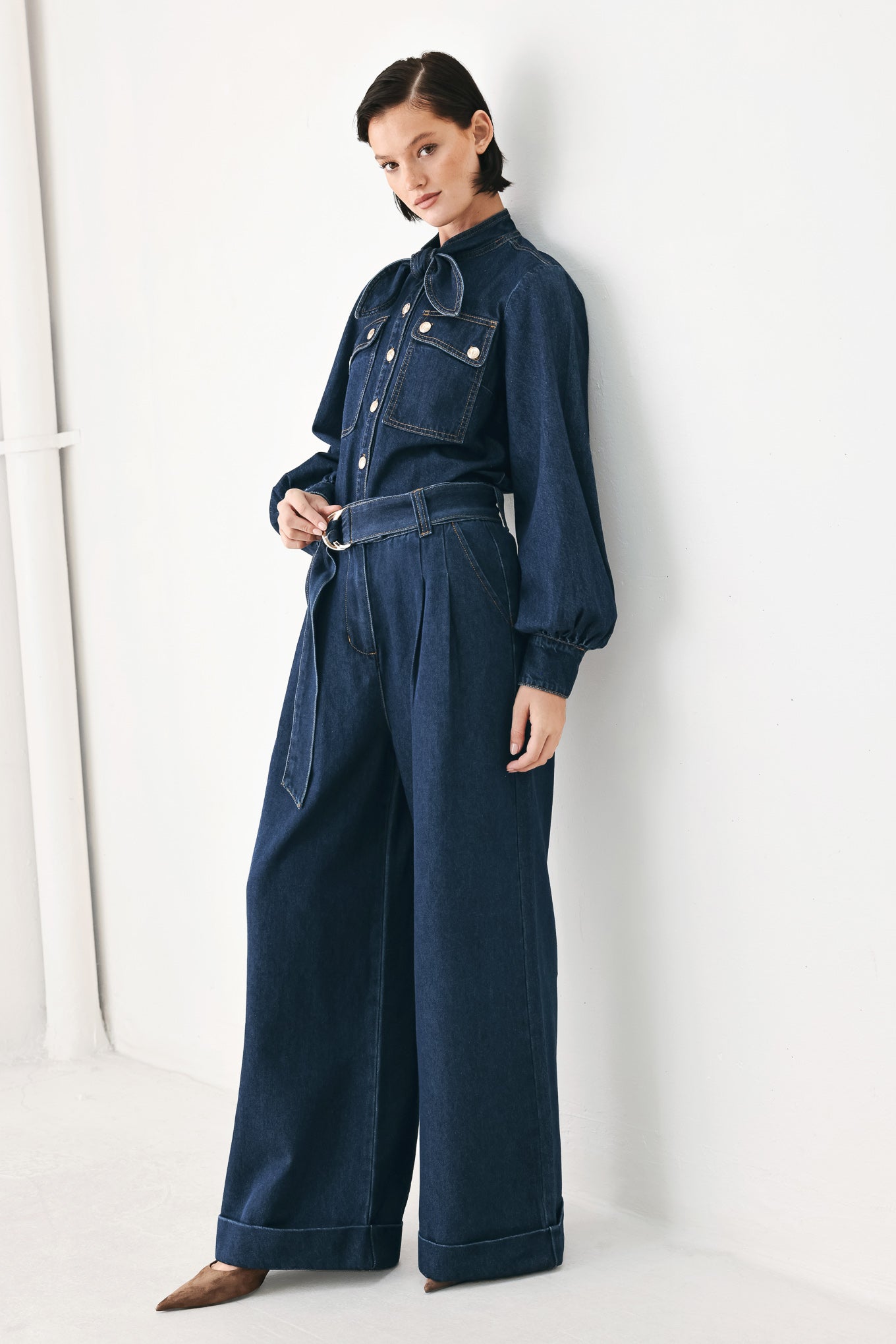 A model wearing a dark blue denim shirt jacket with gold-tone buttons and a bow detail at the collar | FREEMARKET