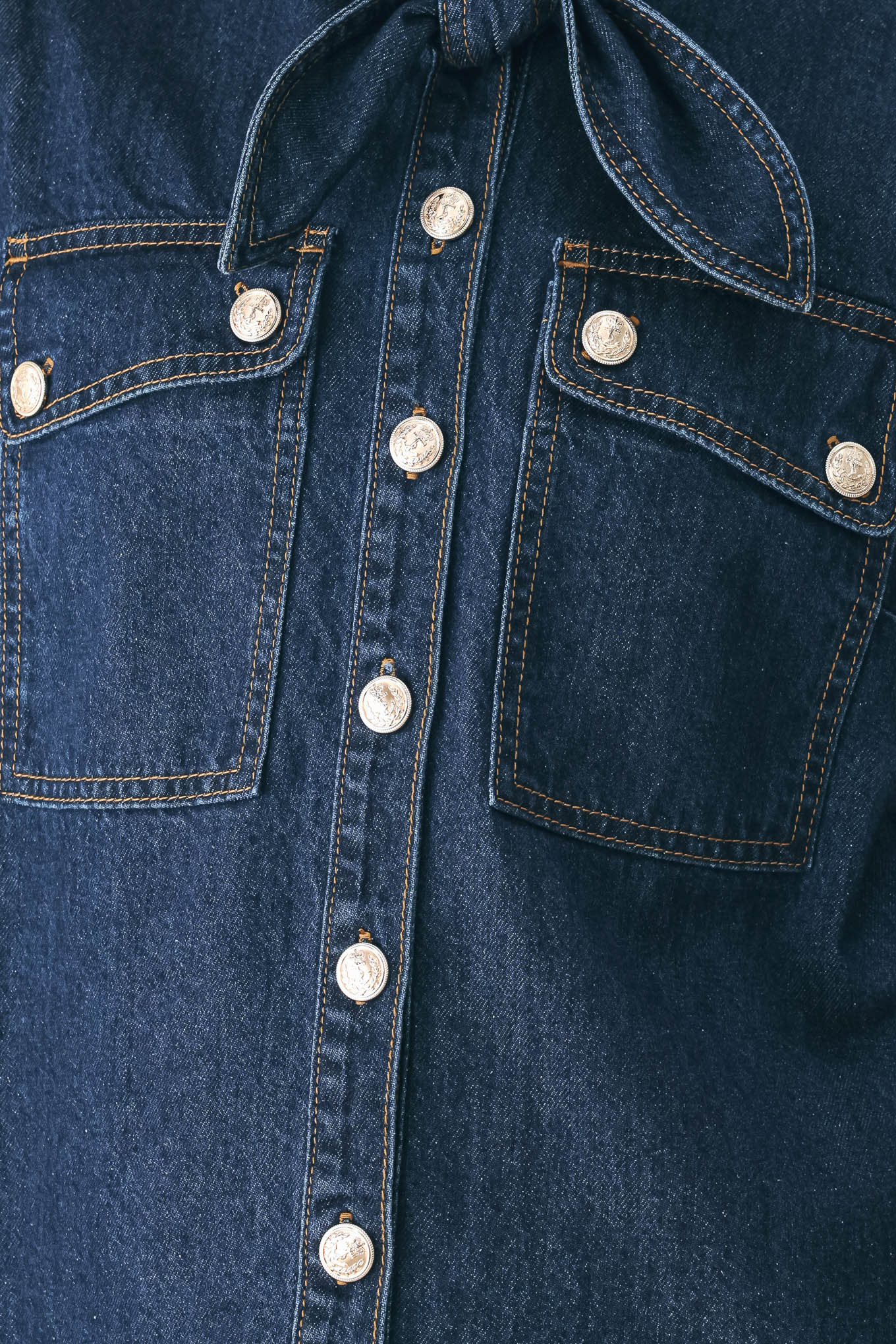 A model wearing a dark blue denim shirt jacket with gold-tone buttons and a bow detail at the collar | FREEMARKET