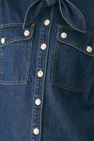A model wearing a dark blue denim shirt jacket with gold-tone buttons and a bow detail at the collar | FREEMARKET