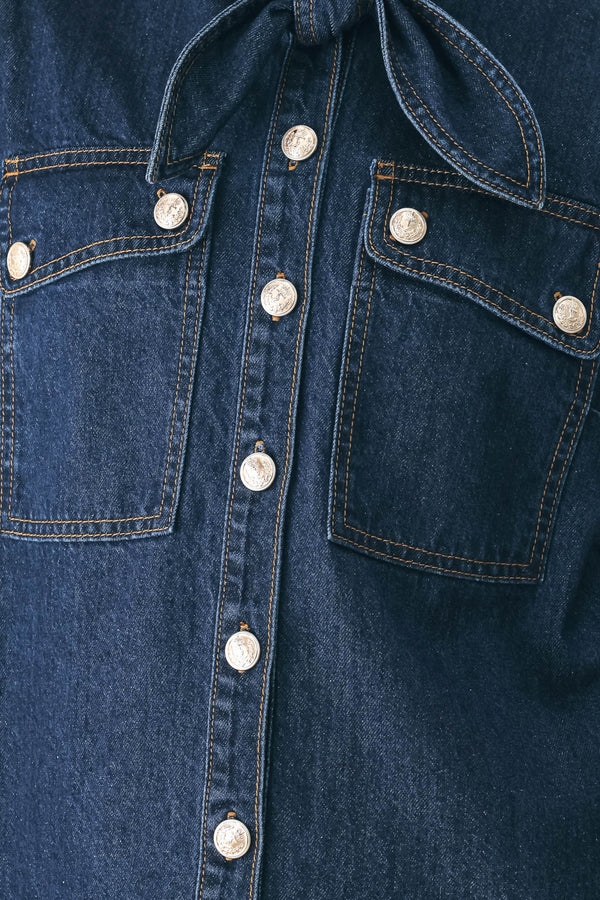 A model wearing a dark blue denim shirt jacket with gold-tone buttons and a bow detail at the collar | FREEMARKET