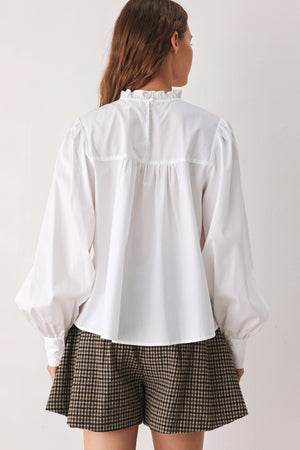 A woman modeling a white long-sleeve blouse with a ruffled high neck, pleated front, and lace detailing | FREEMARKET