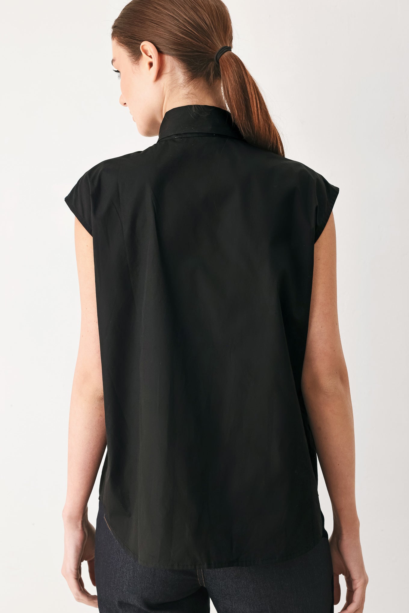 Woman wearing a black woven top with front bow tie and button down | FREEMARKET