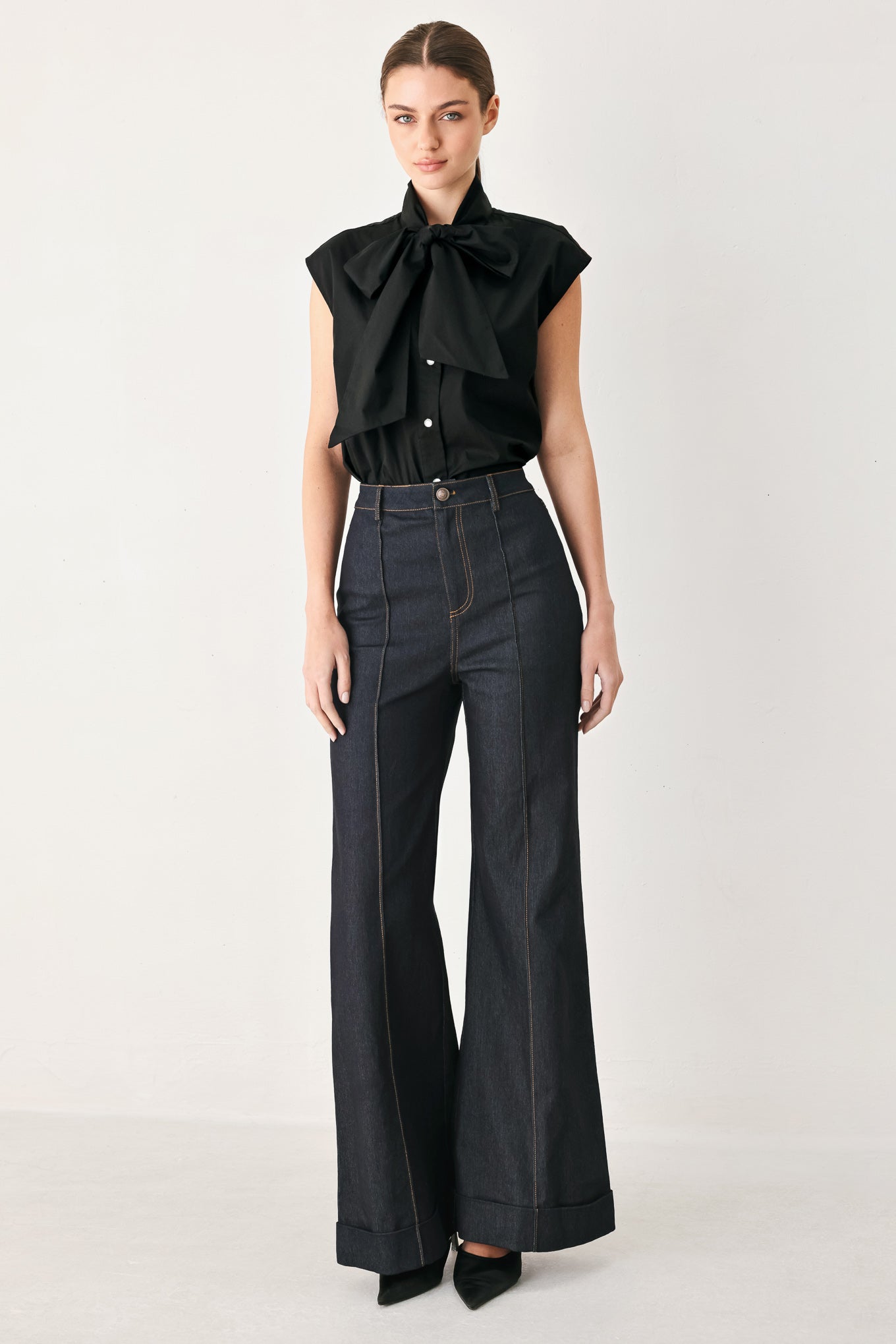 Woman wearing a black woven top with front bow tie and button down | FREEMARKET