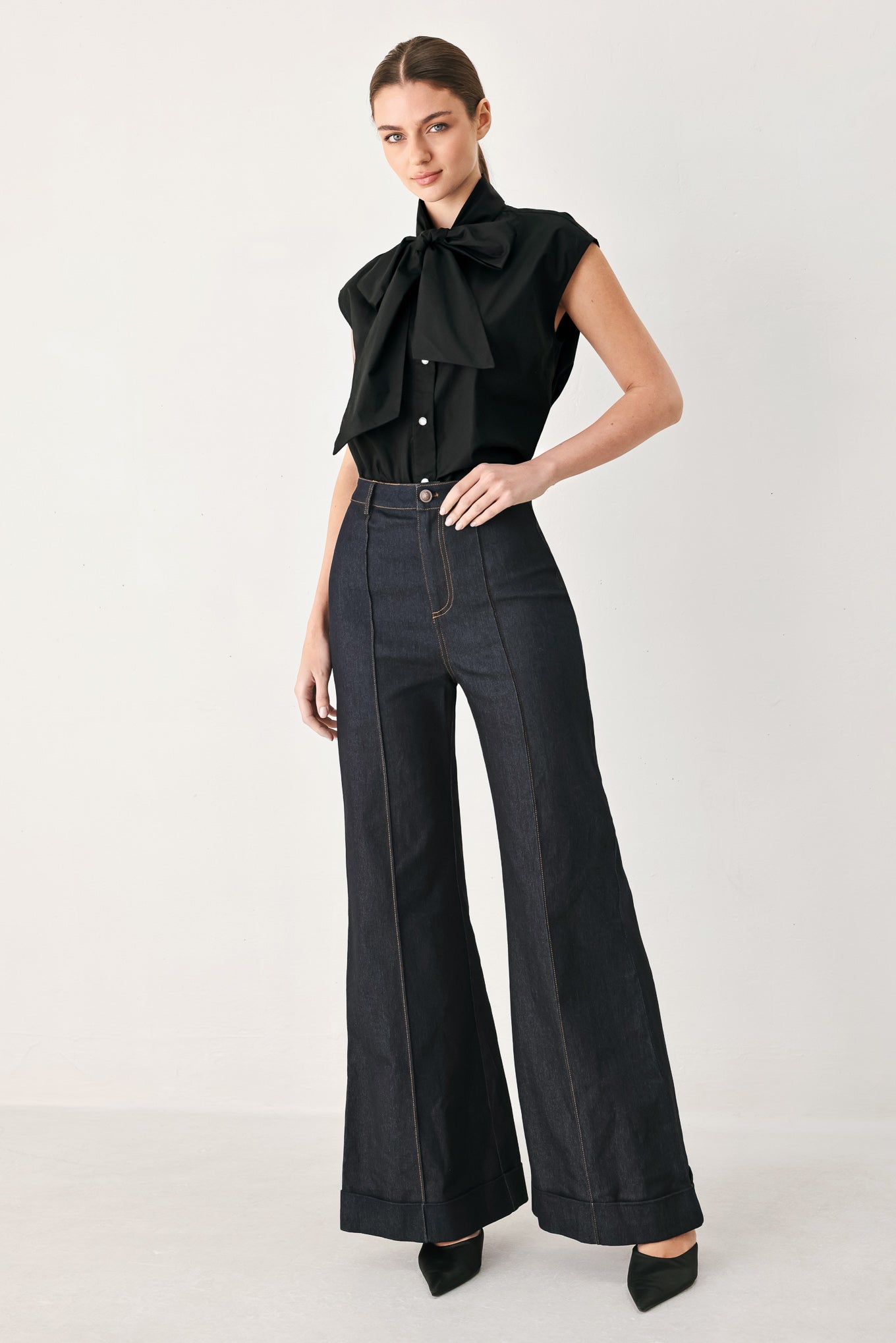 Woman wearing a black woven top with front bow tie and button down | FREEMARKET