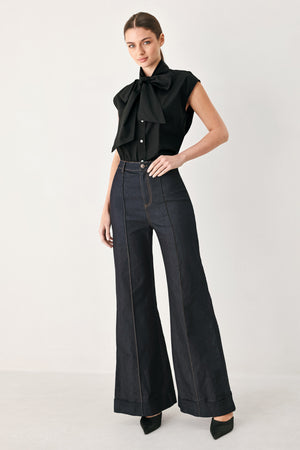 Woman wearing a black woven top with front bow tie and button down | FREEMARKET