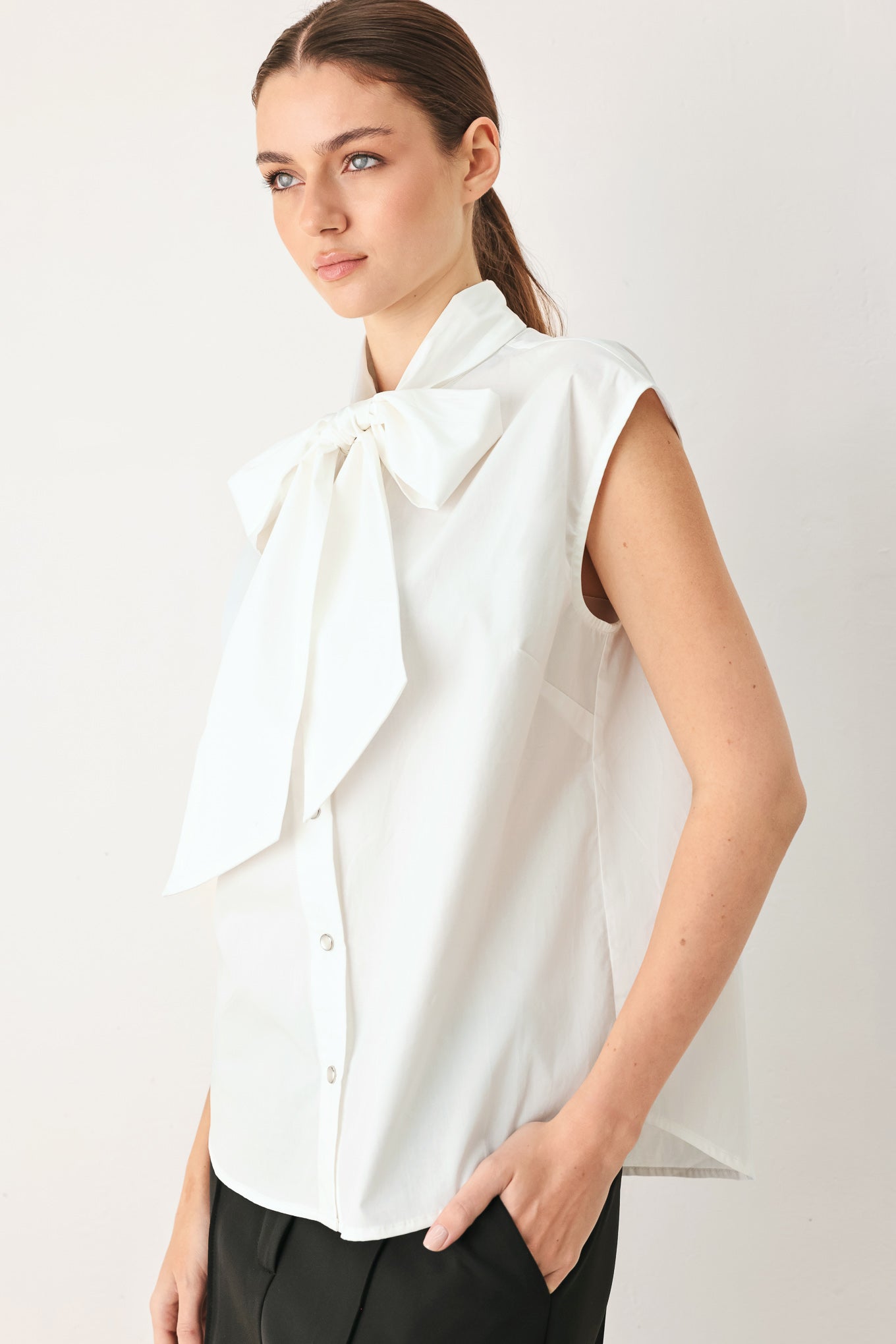 Woman wearing a white woven top with front bow tie and button down | FREEMARKET