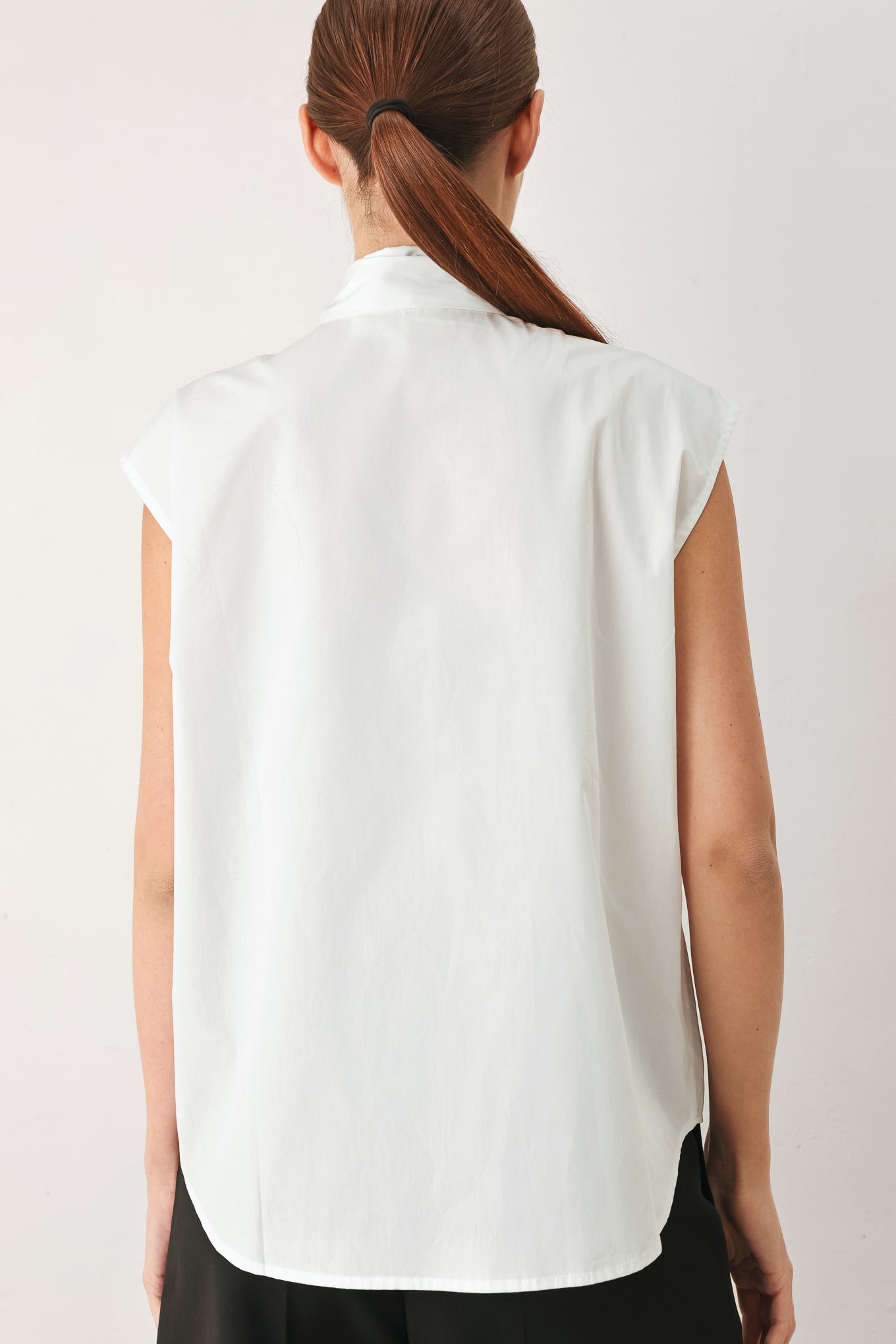 Woman wearing a white woven top with front bow tie and button down | FREEMARKET
