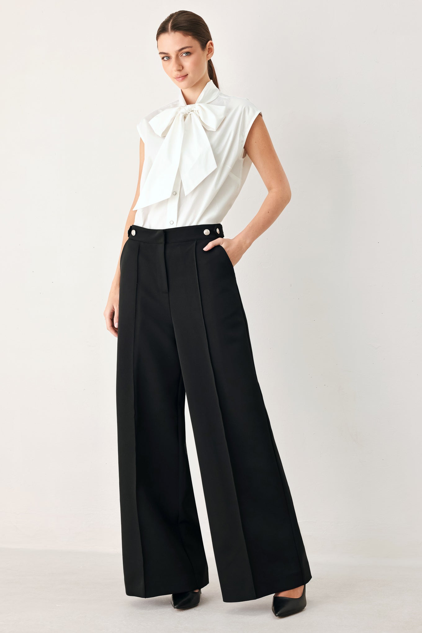 Woman wearing a white woven top with front bow tie and button down | FREEMARKET