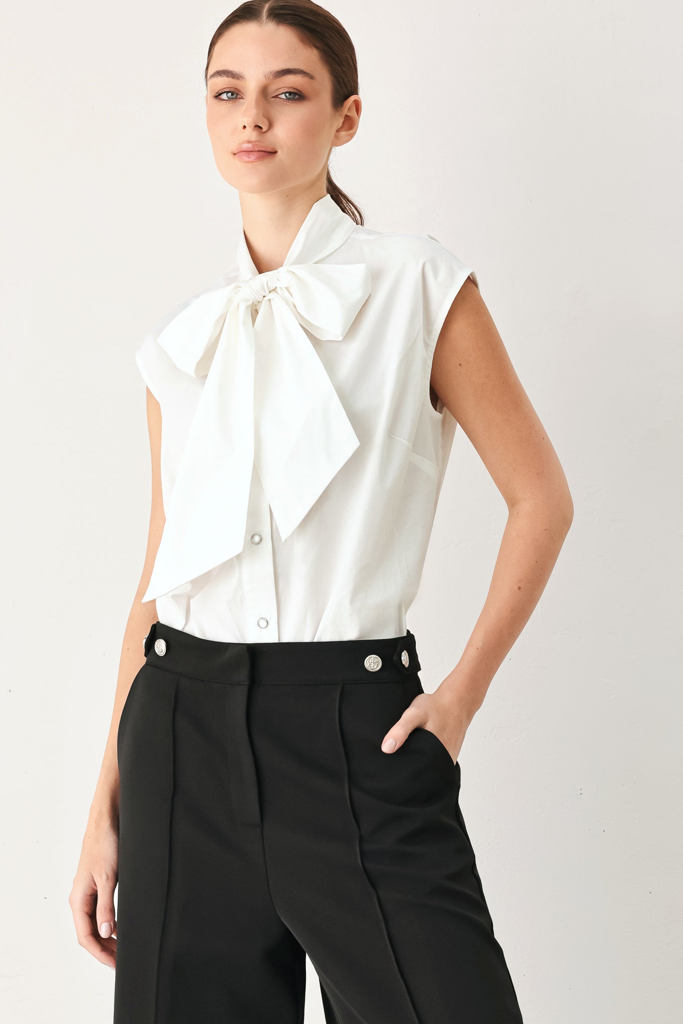 Woman wearing a white woven top with front bow tie and button down | FREEMARKET
