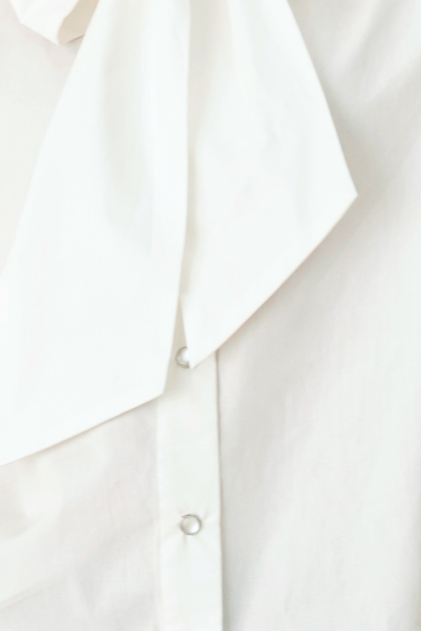Woman wearing a white woven top with front bow tie and button down | FREEMARKET
