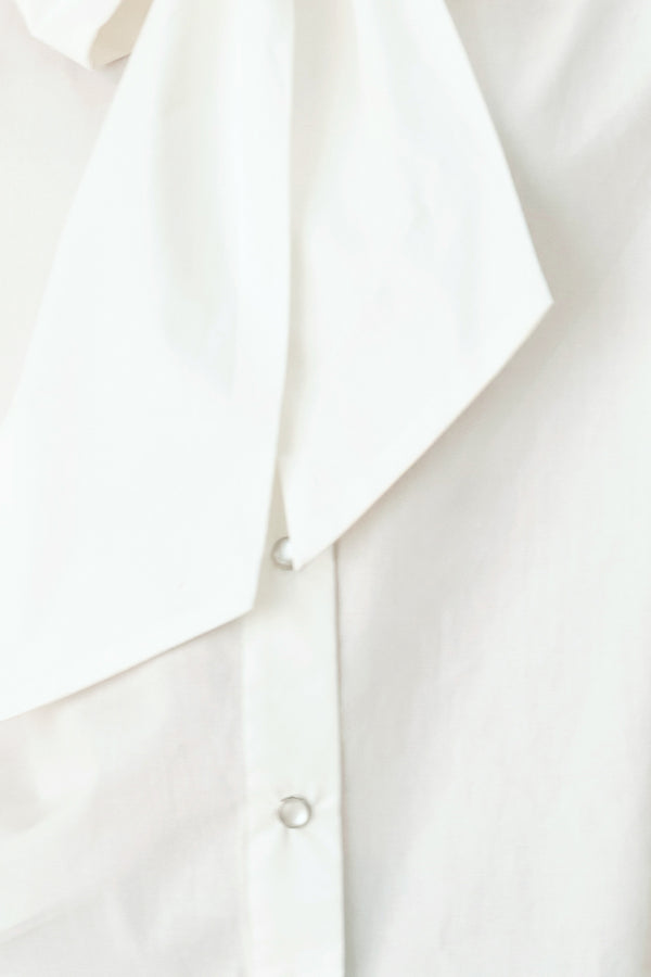 Woman wearing a white woven top with front bow tie and button down | FREEMARKET