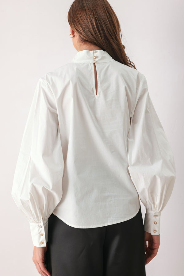 A woman wearing a white long-sleeve blouse with a large draped bow at the collar | FREEMARKET