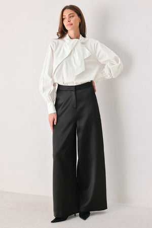 A woman wearing a white long-sleeve blouse with a large draped bow at the collar | FREEMARKET