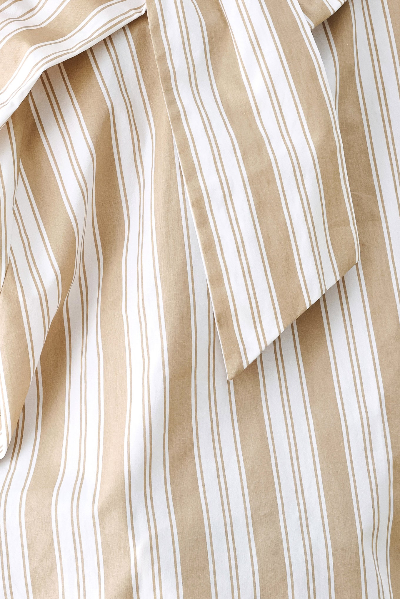 A model wearing a khaki beige and white vertically striped blouse with a large ruffled bow at the collar and voluminous long sleeves | FREEMARKET