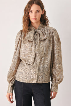 A woman modeling a long-sleeve brown and gold snake-patterned blouse with a tie-neck detail | FREEMARKET