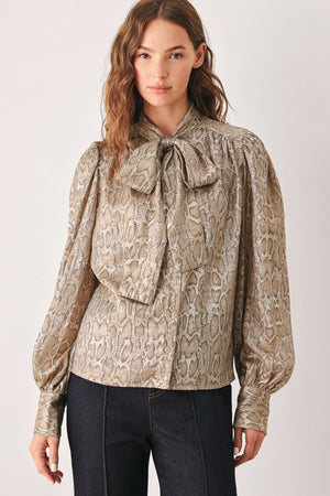 A woman modeling a long-sleeve brown and gold snake-patterned blouse with a tie-neck detail | FREEMARKET