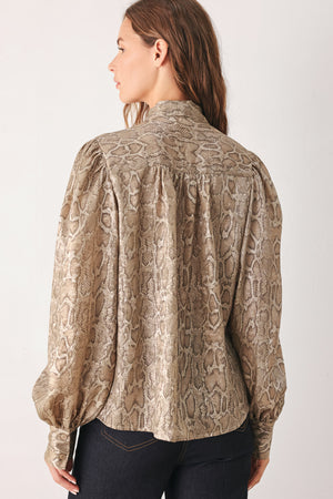 A woman modeling a long-sleeve brown and gold snake-patterned blouse with a tie-neck detail | FREEMARKET