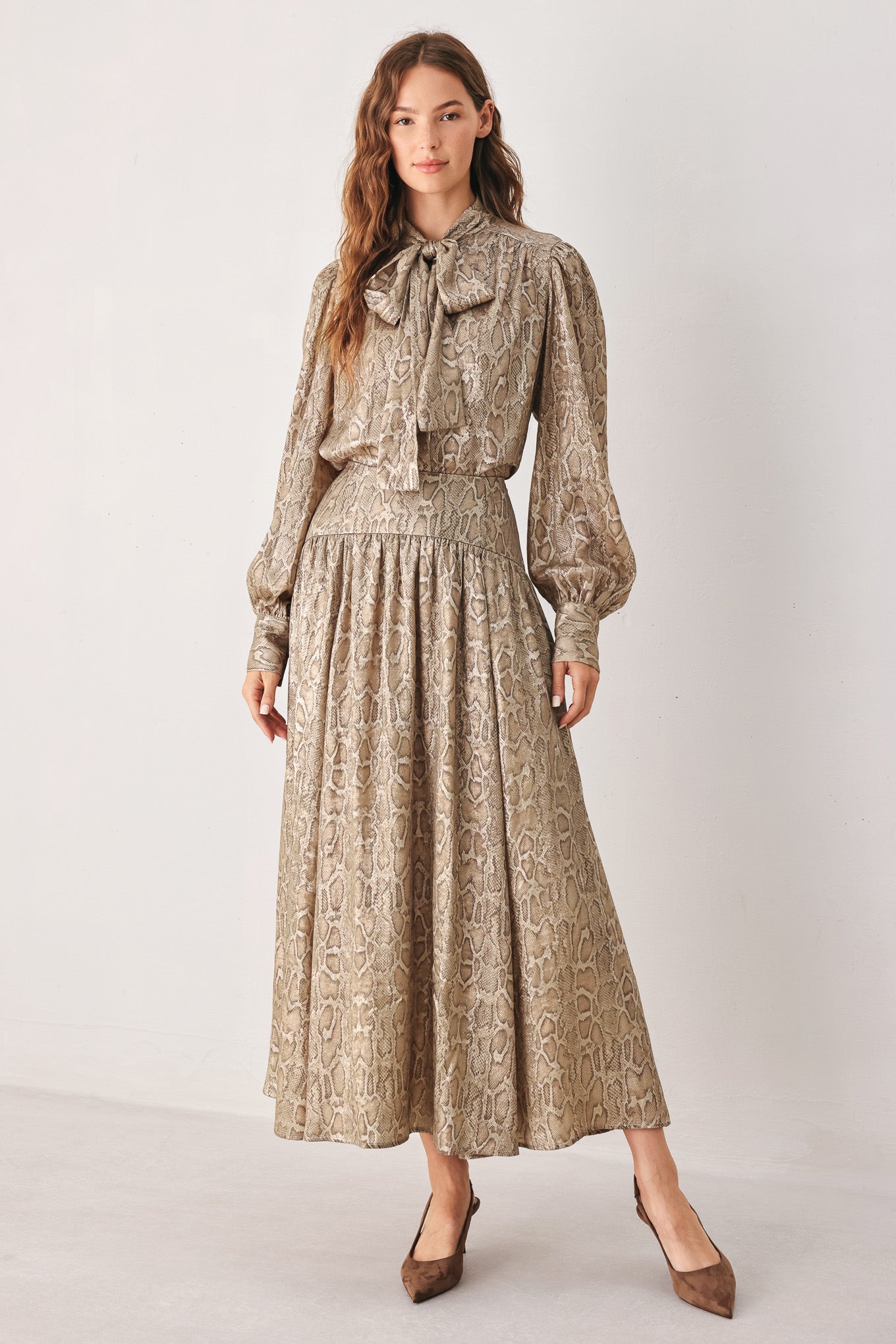 A woman modeling a long-sleeve brown and gold snake-patterned blouse with a tie-neck detail | FREEMARKET