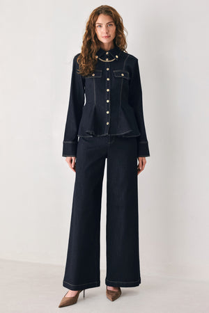 Woman wearing a navy blue denim long sleep button up top with a peplum waist, a collar and chain connected to the corners of the collar | FREEMARKET
