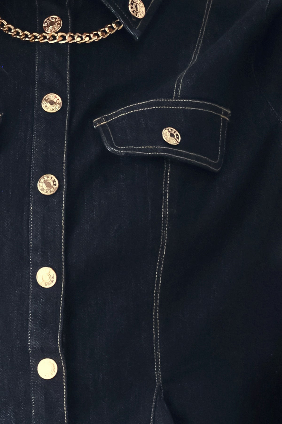 Woman wearing a navy blue denim long sleep button up top with a peplum waist, a collar and chain connected to the corners of the collar | FREEMARKET