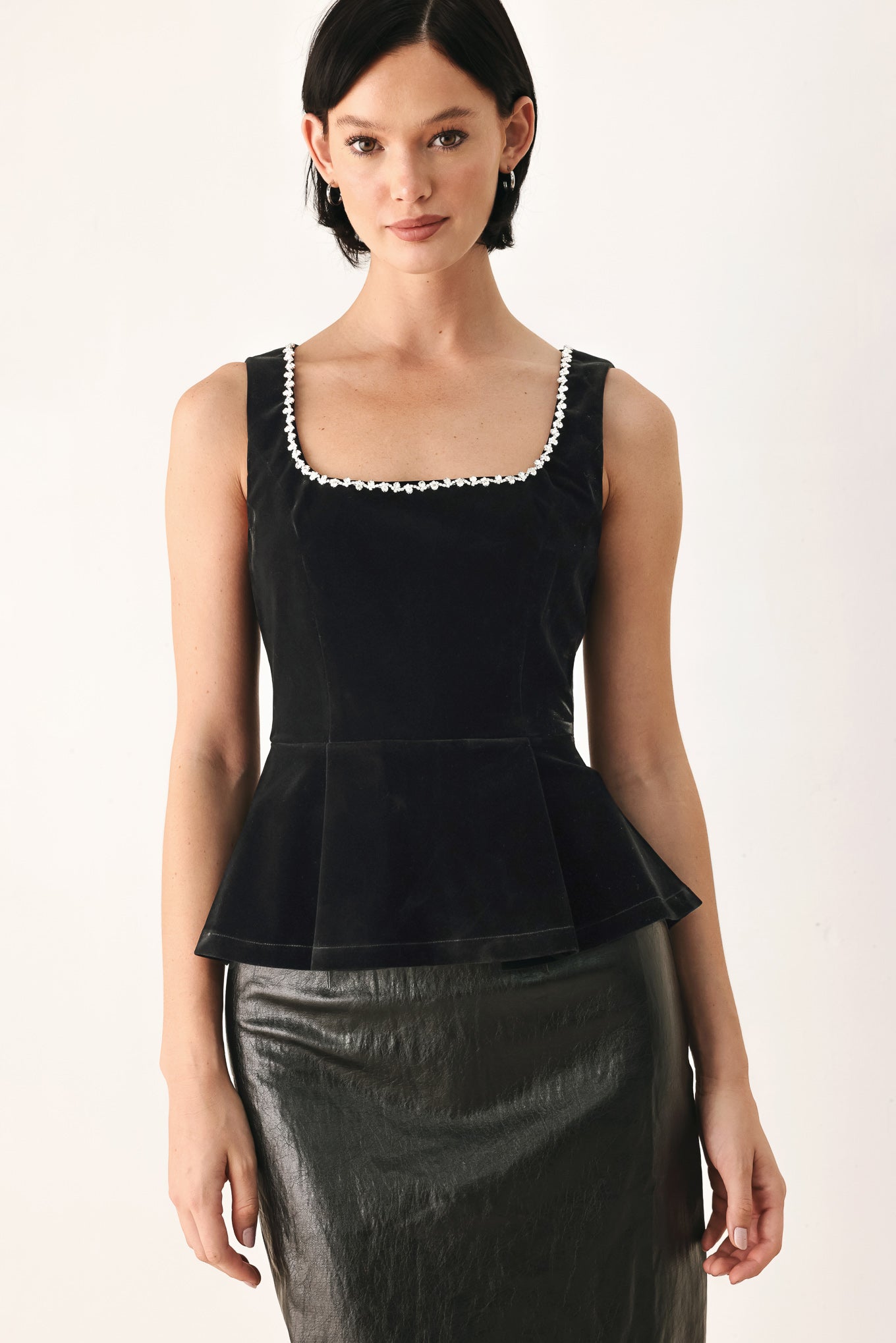 A woman modeling a black velvet sleeveless top with a pearl-trimmed square neckline and a peplum waist | FREEMARKET