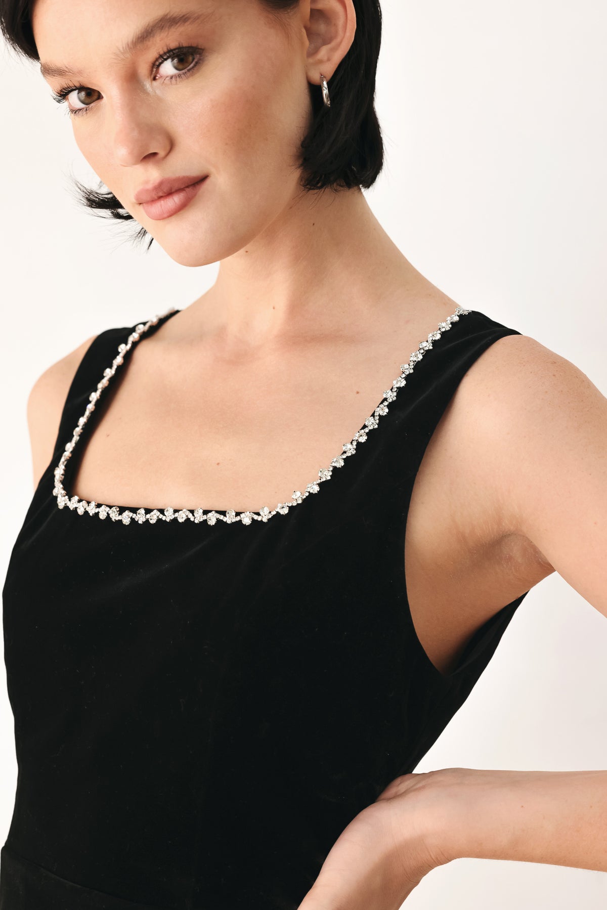 A woman modeling a black velvet sleeveless top with a pearl-trimmed square neckline and a peplum waist | FREEMARKET