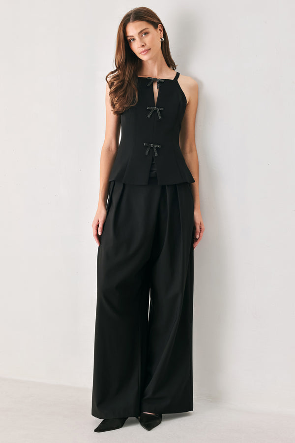 A woman wearing a black sleeveless top with bow details | FREEMARKET