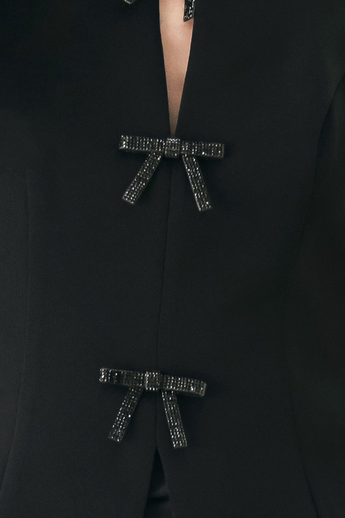 A woman wearing a black sleeveless top with bow details | FREEMARKET