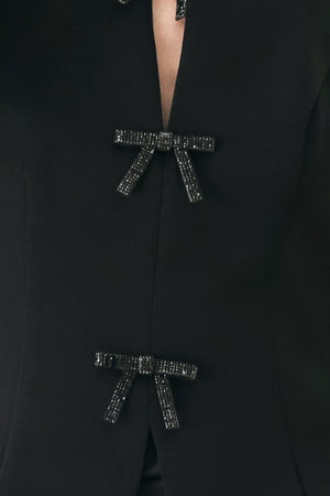 A woman wearing a black sleeveless top with bow details | FREEMARKET