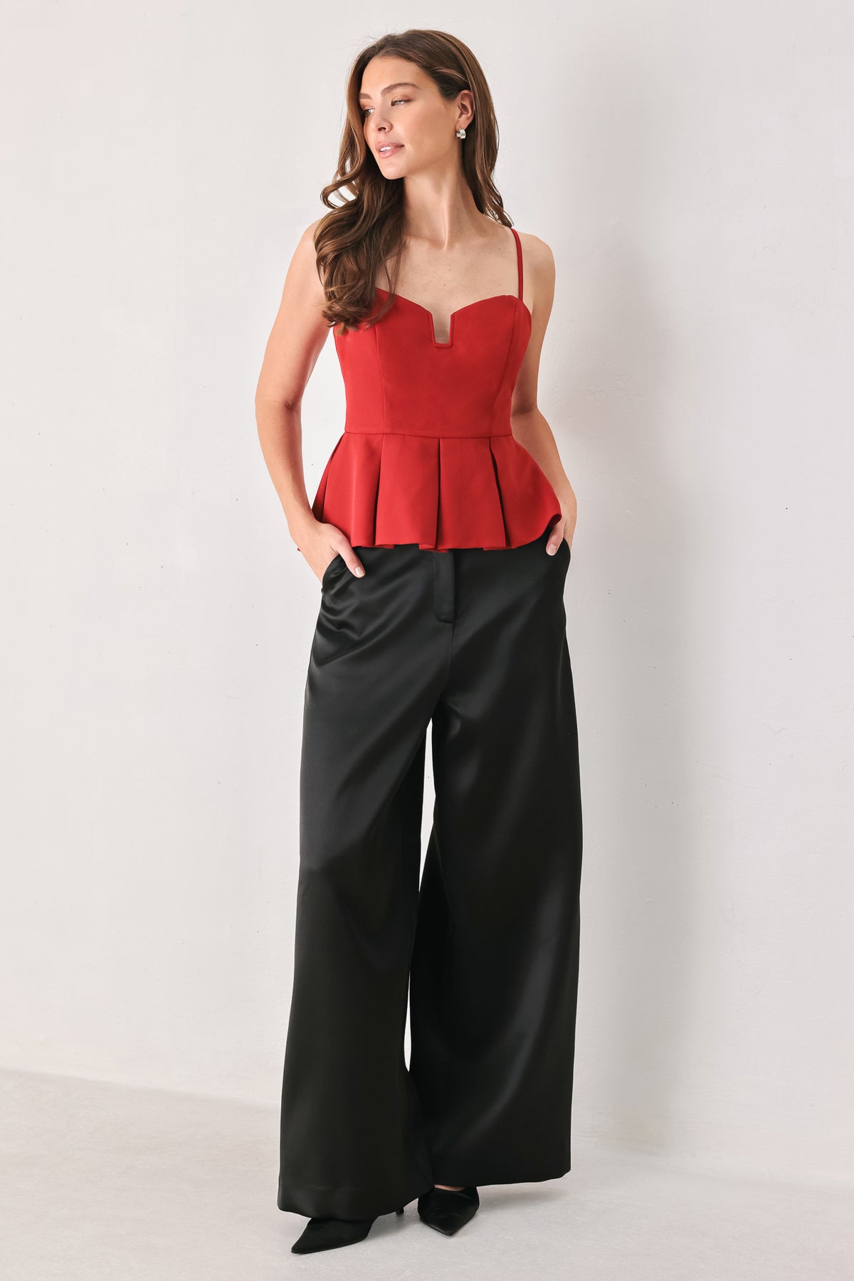 A woman modeling a red spaghetti-strap peplum top with a sweetheart neckline and keyhole cutout | FREEMARKET