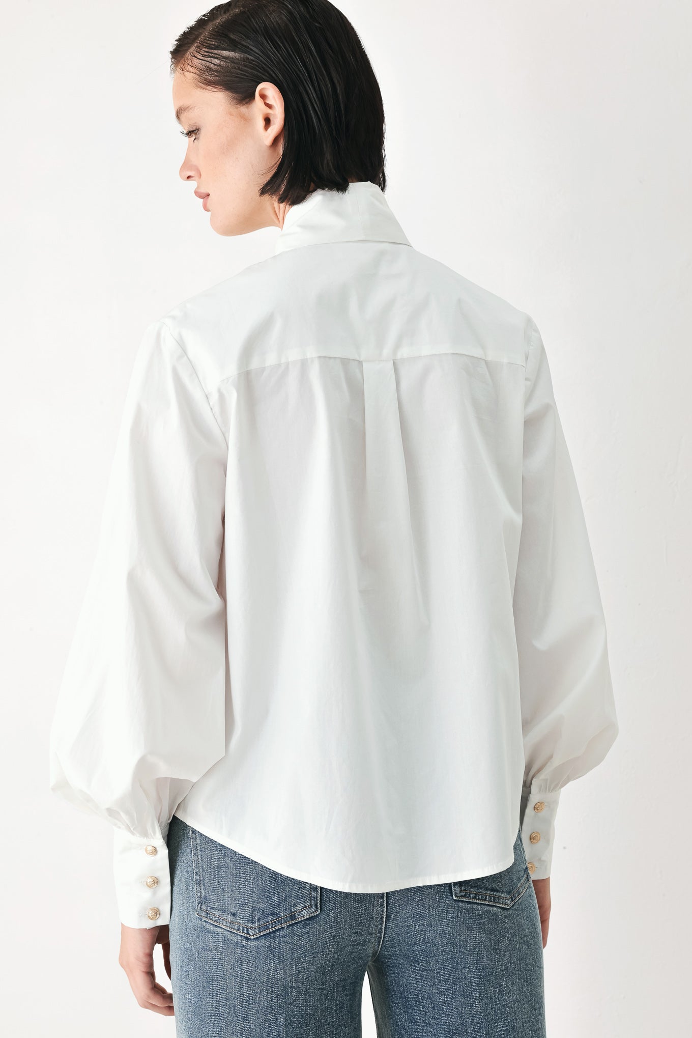 A woman wearing a white long-sleeve blouse with a large bow at the collar | FREEMARKET