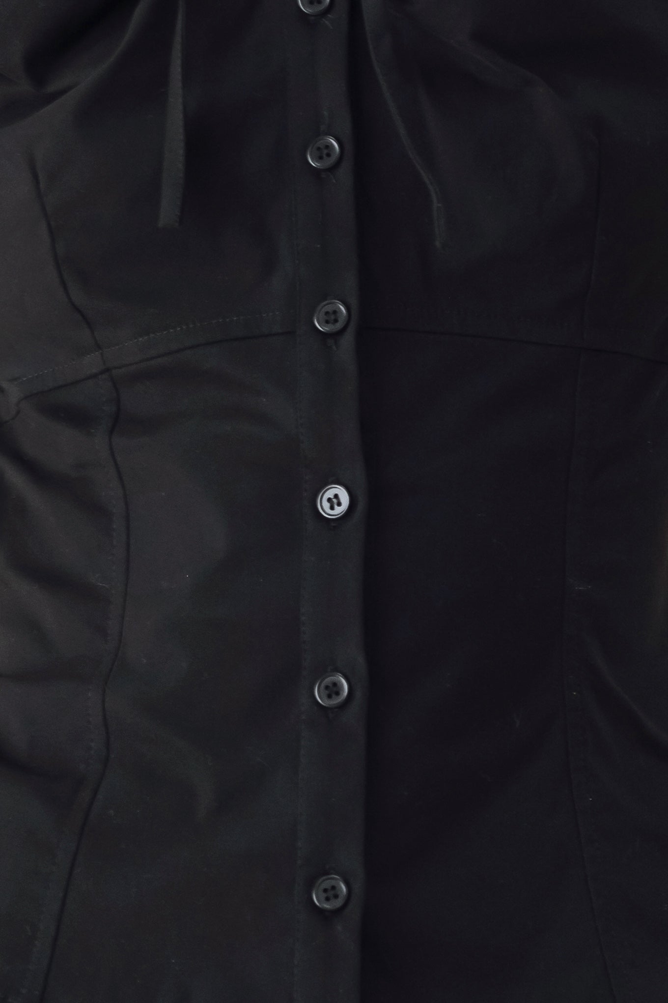 A woman wearing a black short-sleeve blouse with puff sleeves, a ruffled collar, and a keyhole cutout at the neckline | FREEMARKET