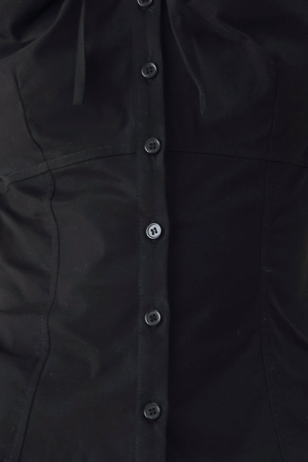 A woman wearing a black short-sleeve blouse with puff sleeves, a ruffled collar, and a keyhole cutout at the neckline | FREEMARKET