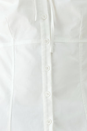 A woman wearing a white short-sleeve blouse with puff sleeves, a ruffled collar, and a keyhole cutout at the neckline | FREEMARKET