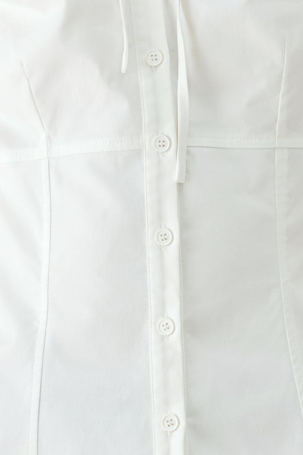 A woman wearing a white short-sleeve blouse with puff sleeves, a ruffled collar, and a keyhole cutout at the neckline | FREEMARKET