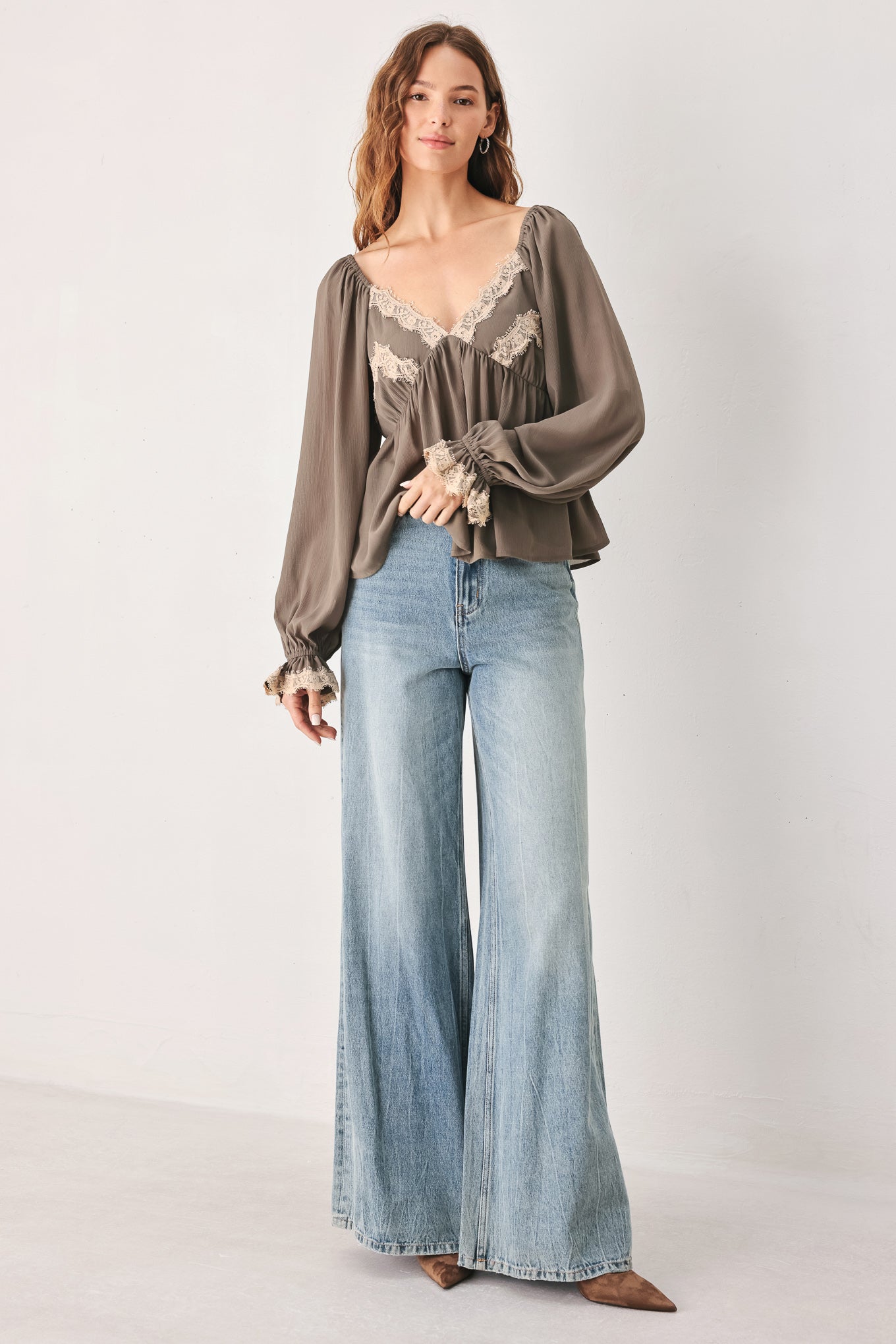 A woman wearing a taupe-brown long-sleeve blouse with beige lace trim on the neckline and cuffs | FREEMARKET